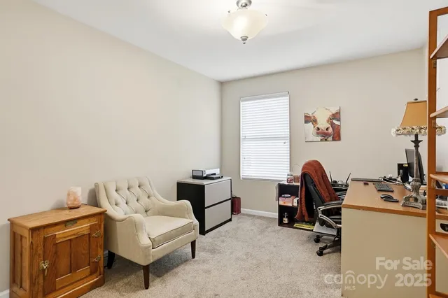 a view of a workspace with furniture and a window