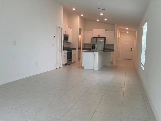 an empty room with a window and a ceiling fan