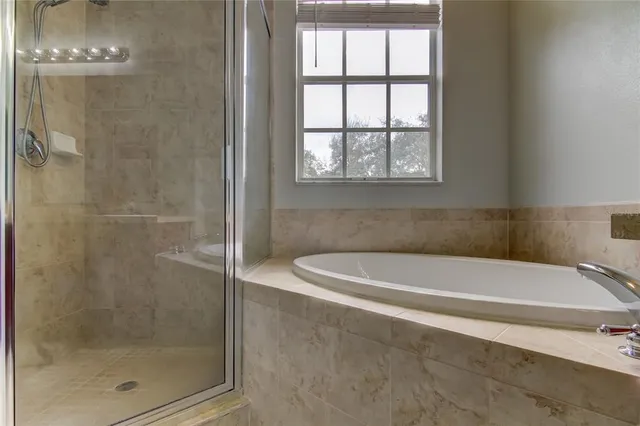 a white bath tub sitting next to a shower