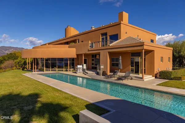 a front view of house with swimming pool yard and outdoor seating