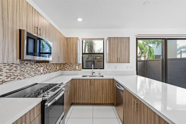 a view of kitchen with sink microwave and cabinets