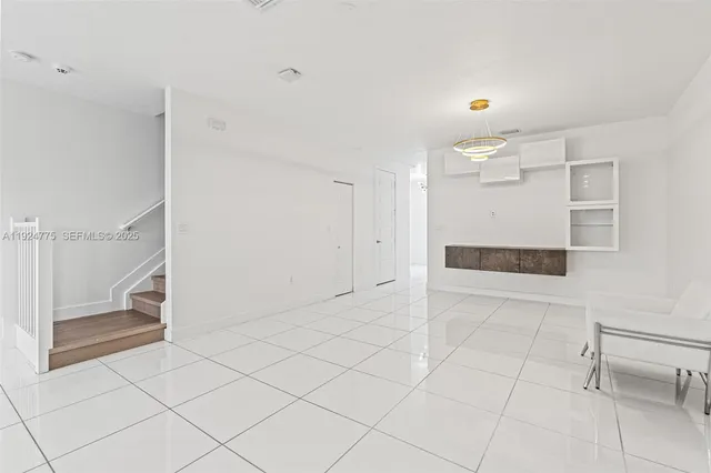 a view of kitchen with granite countertop cabinets and refrigerator