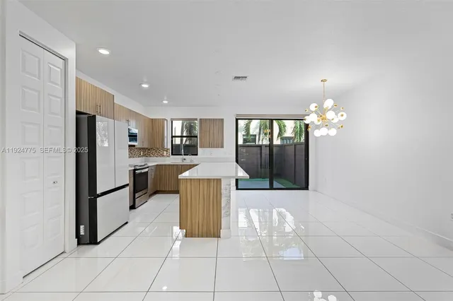 a kitchen with kitchen island granite countertop a sink stove and refrigerator