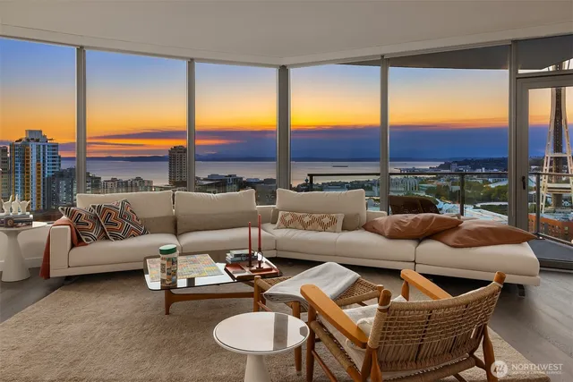 a living room with furniture kitchen view and large windows
