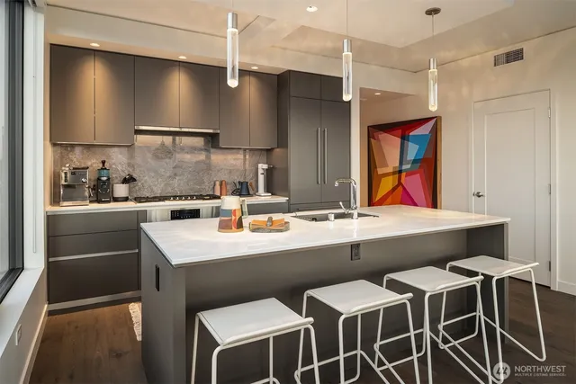 a kitchen with a sink and chairs