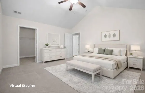a spacious bedroom with a bed and a chandelier