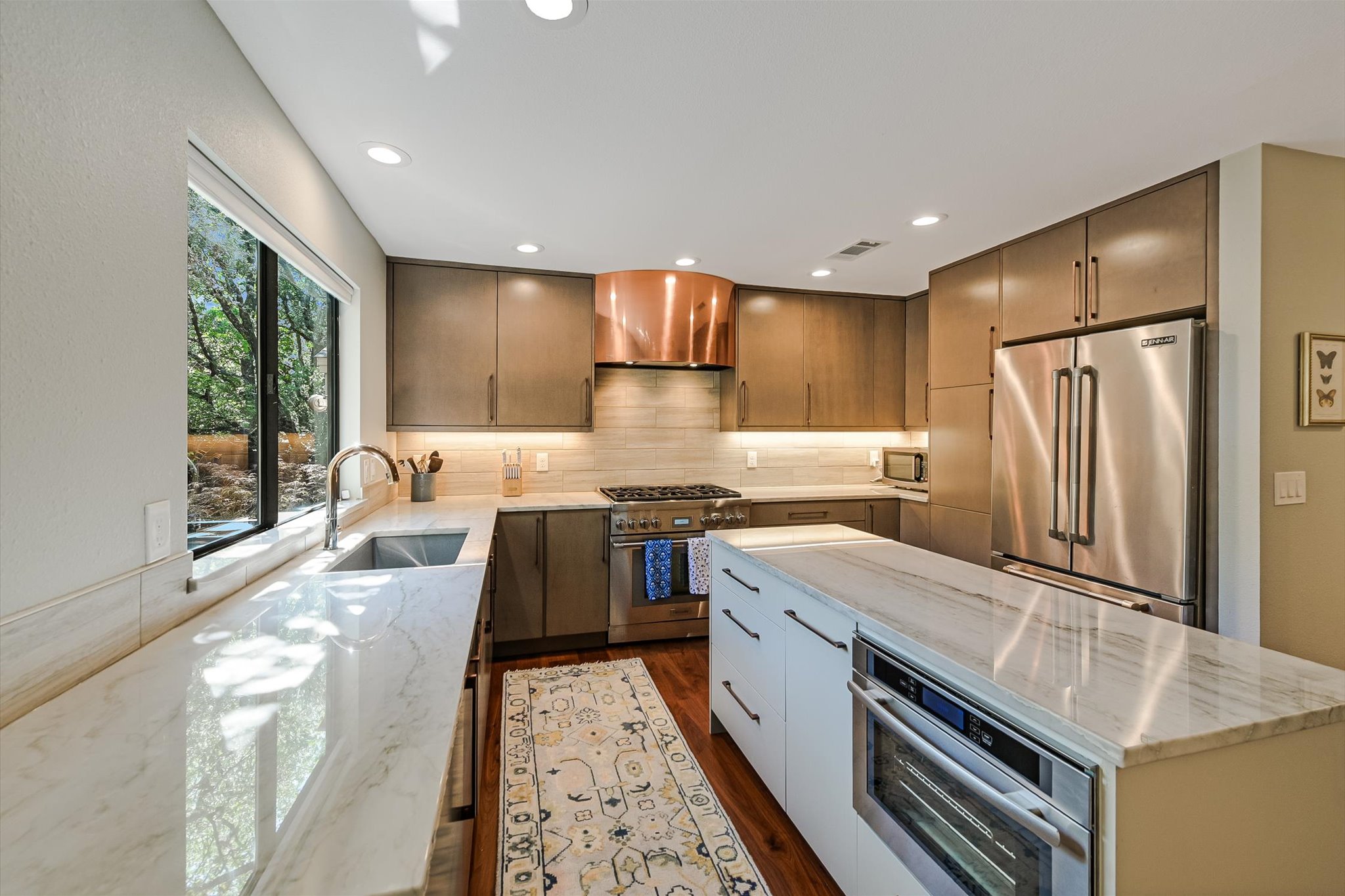 8121 Raintree Place Austin, TX 78759 - Photo 2 of 26 Quartz counter tops, center island with steam over, custom-designed copper vent hood