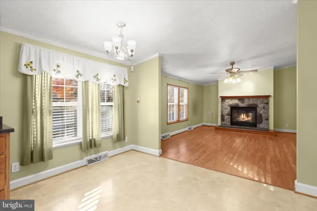 a view of an empty room with a fireplace and a window