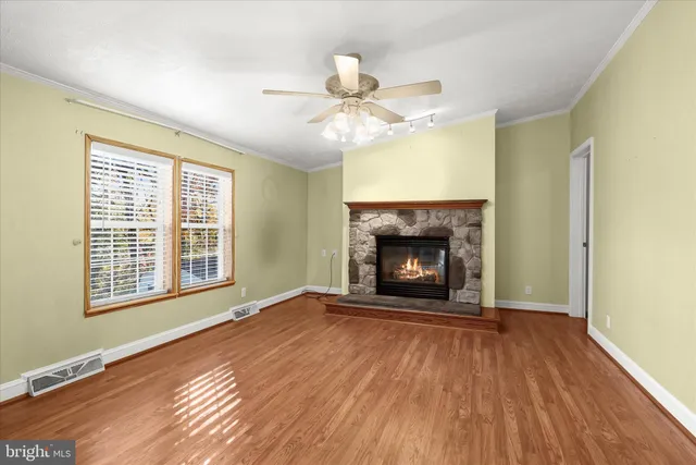 a view of an empty room with a fireplace and a window