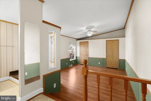 a view of a hallway with wooden floor and stairs