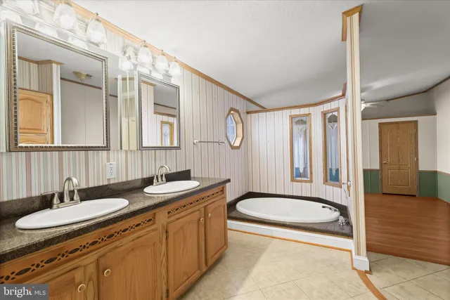 a bathroom with a granite countertop sink toilet a mirror a bathtub and shower