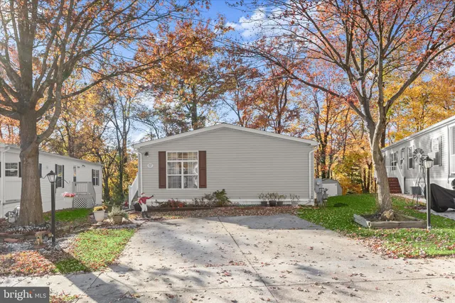 a front view of a house with a yard and large tree