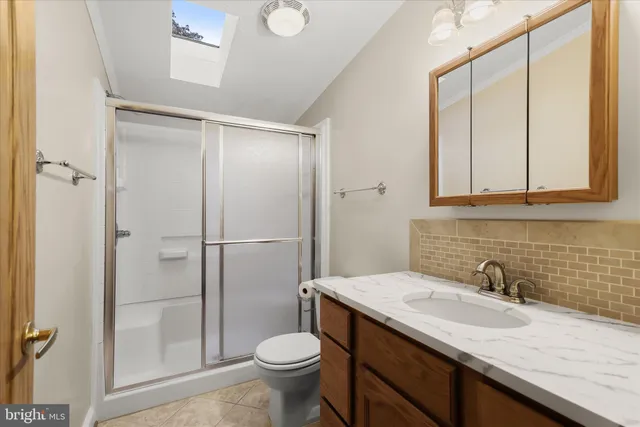 a bathroom with a granite countertop sink toilet and shower