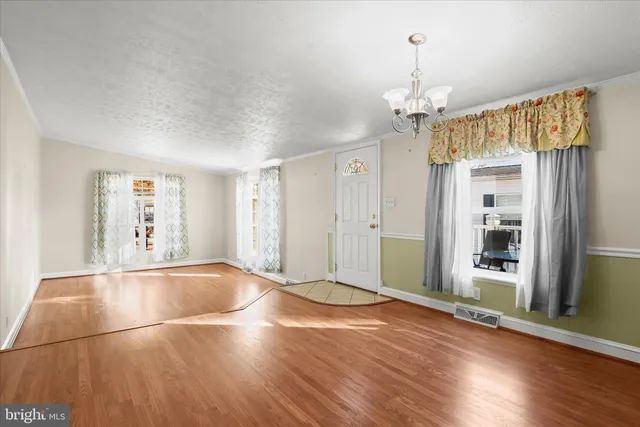 a view of a livingroom with wooden floor and a ceiling fan