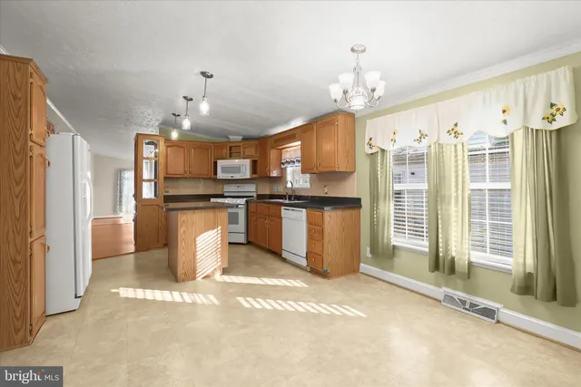 a view of a kitchen with stainless steel appliances granite countertop a refrigerator and a stove top oven