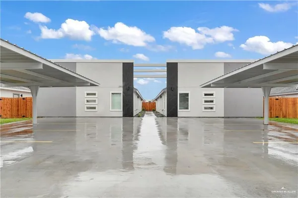 a view of an empty room with wooden floor and a ceiling fan