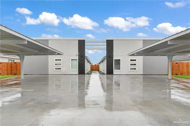 a view of an empty room with wooden floor and a ceiling fan