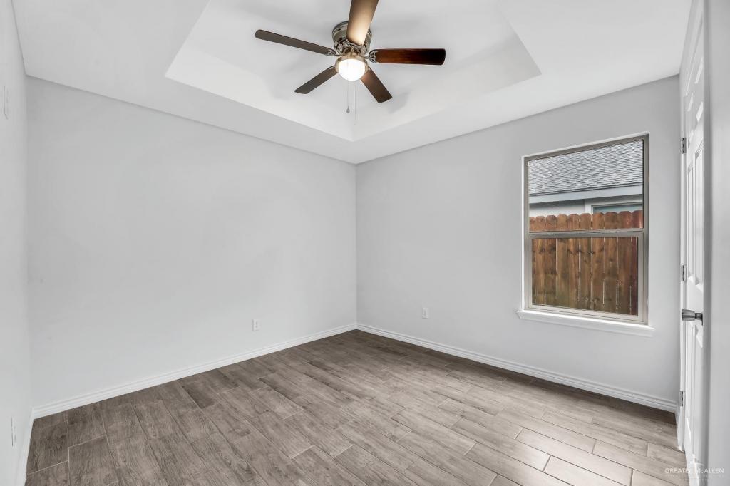 1001 West Sunset Valley Street, Unit 2 Alton, TX 78573 - Photo 11 of 13 an empty room with a window and a ceiling fan