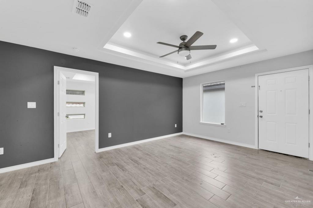 1001 West Sunset Valley Street, Unit 2 Alton, TX 78573 - Photo 2 of 13 a view of an empty room with wooden floor and a ceiling fan