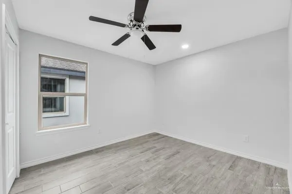 an empty room with a window and a ceiling fan