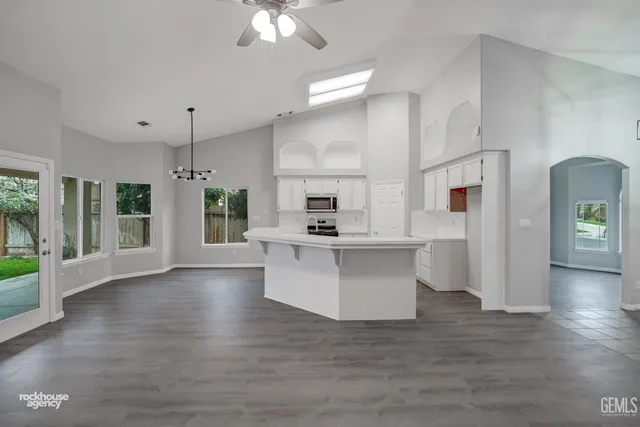 a view of a kitchen with a sink a stove and wooden floor