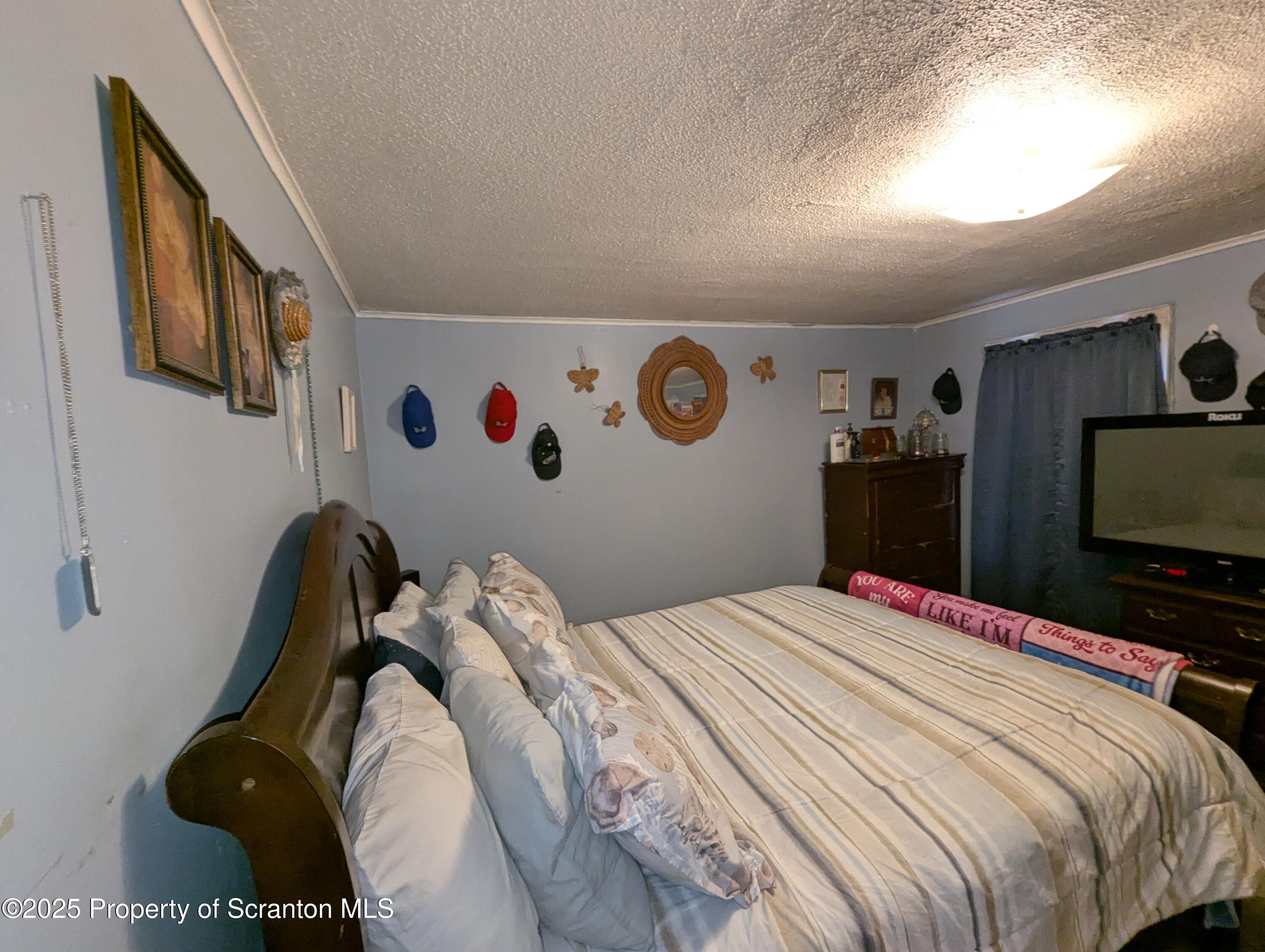 846 Capouse Avenue Scranton, PA 18509 - Photo 26 of 35 a bedroom with a bed and a flat screen tv