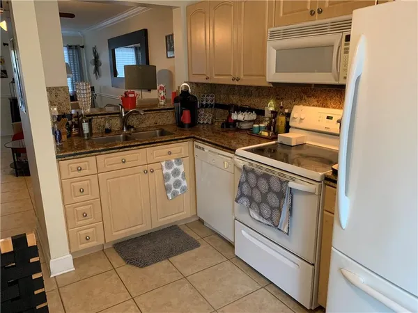 a kitchen with white cabinets and appliances