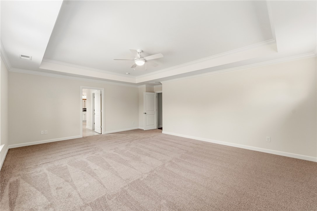 1108 Manse Jolly Road Anderson, SC 29621 - Photo 24 of 45 This spacious primary bedroom features tray ceilings and plush carpeting, offering comfort and style.
