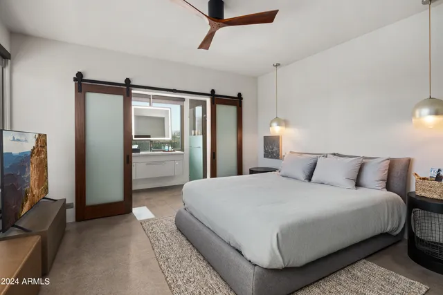 a bedroom with a bed and glass wall