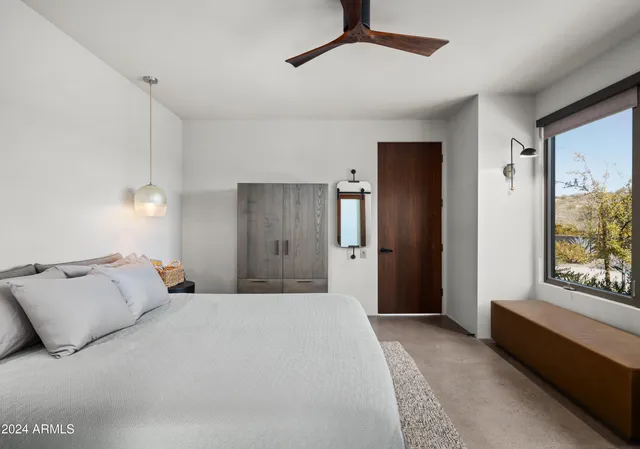 a bedroom with a bed and a refrigerator