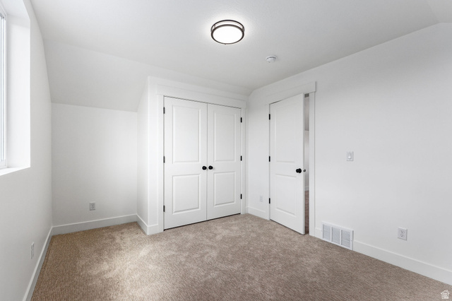 1144 South 4475 West West Point, UT 84015 - Photo 22 of 30 Bedroom featuring plush carpet flooring, white painted walls, a built-in closet with bifold doors, and a window for natural light