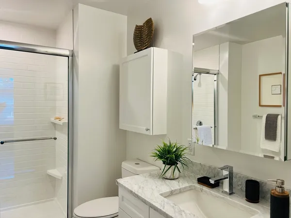 a bathroom with a granite countertop sink toilet and shower