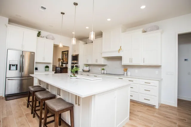 a kitchen with white cabinets and stainless steel appliances