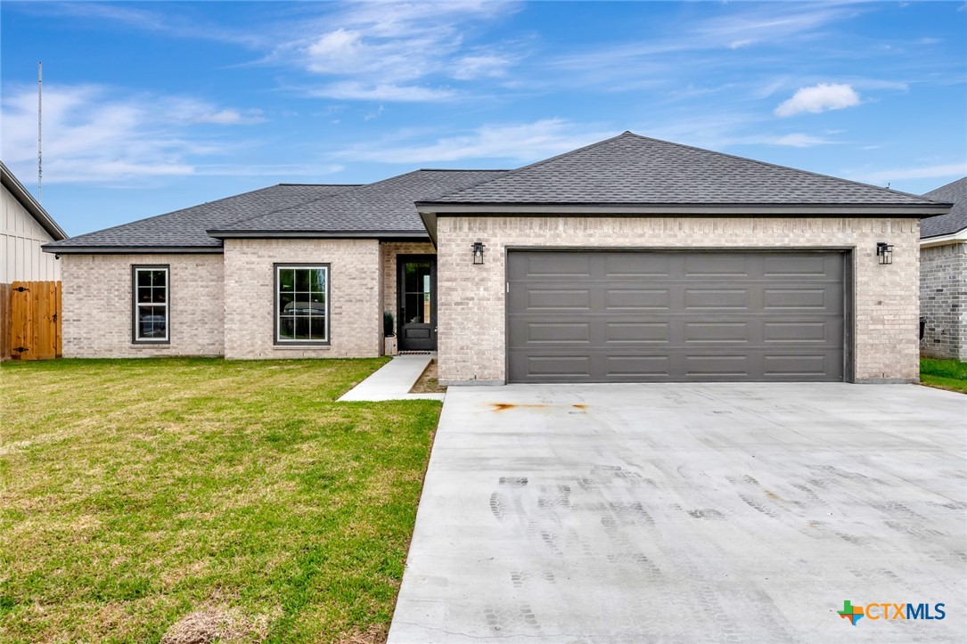 a front view of a house with a yard and garage