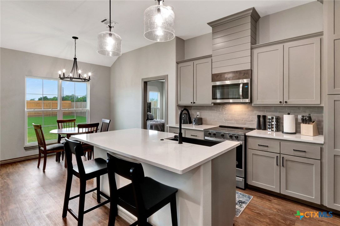 305 Turkey Lane Victoria, TX 77905 - Photo 11 of 35 a kitchen with stainless steel appliances granite countertop a stove a sink dishwasher a stove a refrigerator a dining table and chairs with wooden floor