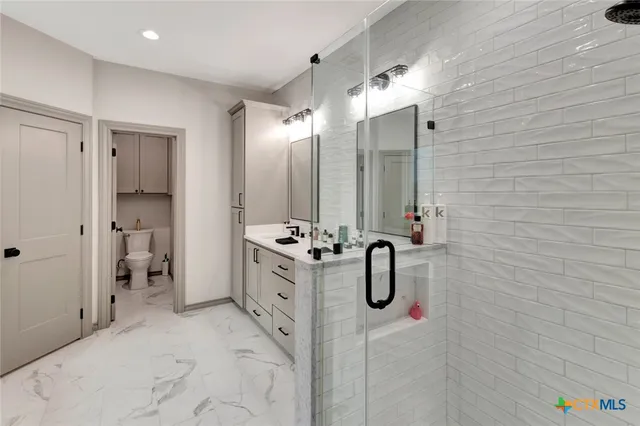 a bathroom with a double sink shower and a mirror