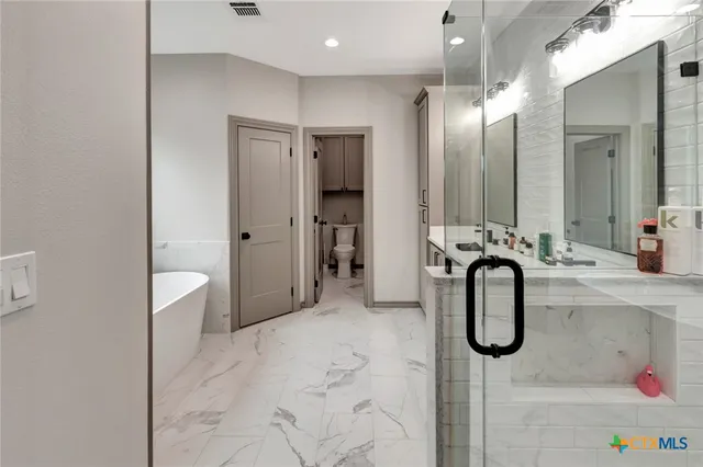 a bathroom with a double vanity sink mirror and shower