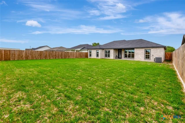 a view of a house with a big yard and large trees