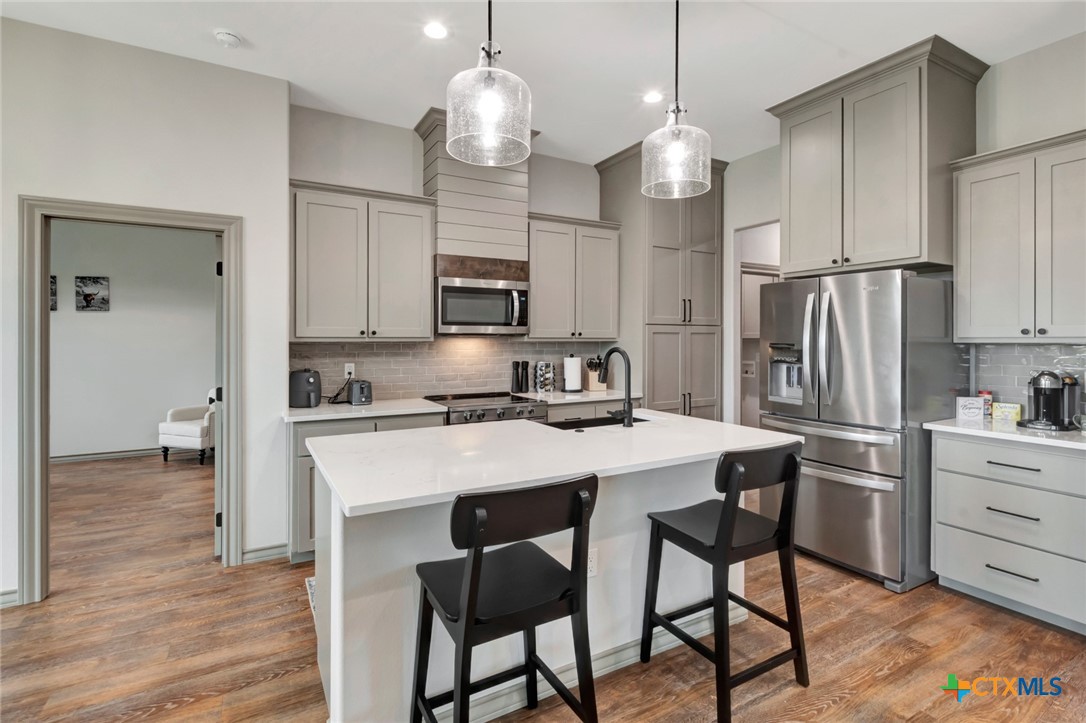305 Turkey Lane Victoria, TX 77905 - Photo 7 of 35 a kitchen with kitchen island granite countertop wooden cabinets and refrigerator