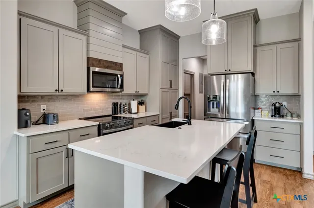 a kitchen with a white cabinets and stainless steel appliances