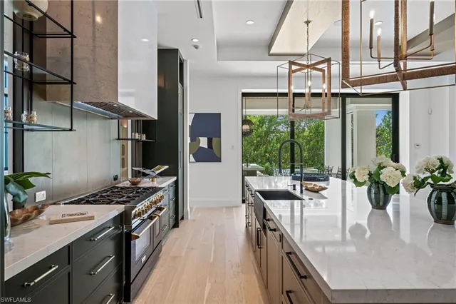 a kitchen with stainless steel appliances granite countertop a sink a stove and a refrigerator