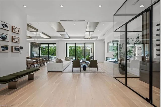 a living room with furniture a large window and wooden floor