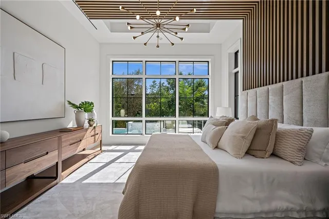 a spacious bedroom with a large bed and a chandelier