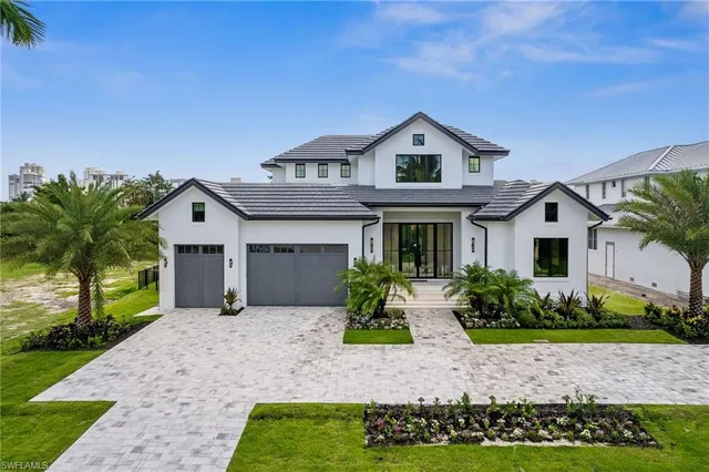 a view of a house with a yard and potted plants