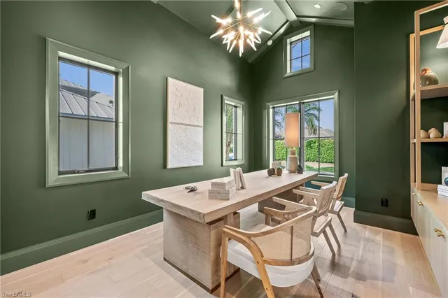 a view of a dining room with furniture a chandelier and window