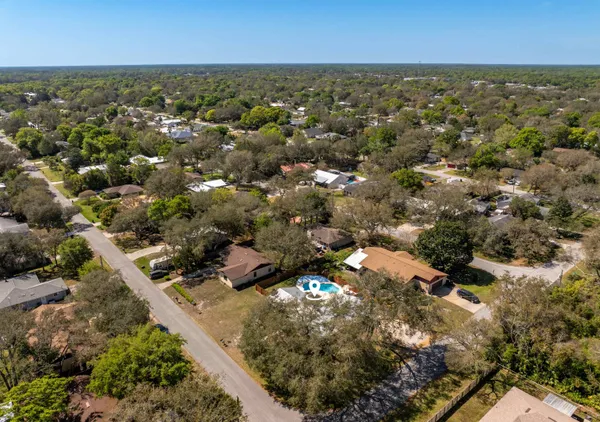an aerial view of residential houses with outdoor space and trees