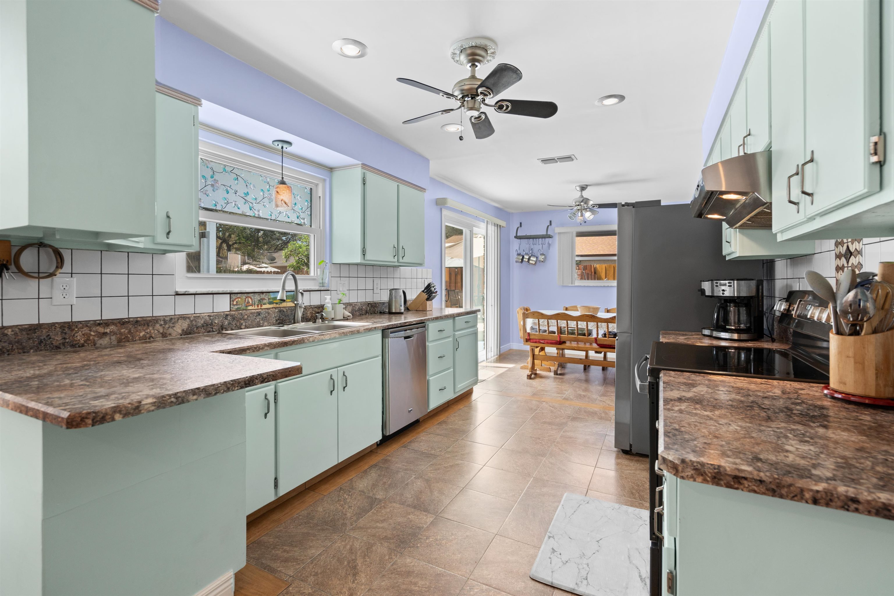 702 Queen Road St. Augustine, FL 32086 - Photo 31 of 71 a kitchen with stainless steel appliances granite countertop sink stove top oven table and chairs