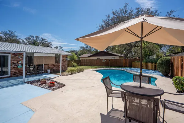 a view of a house with swimming pool and a yard
