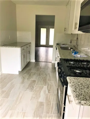 a kitchen with a sink a stove and a microwave