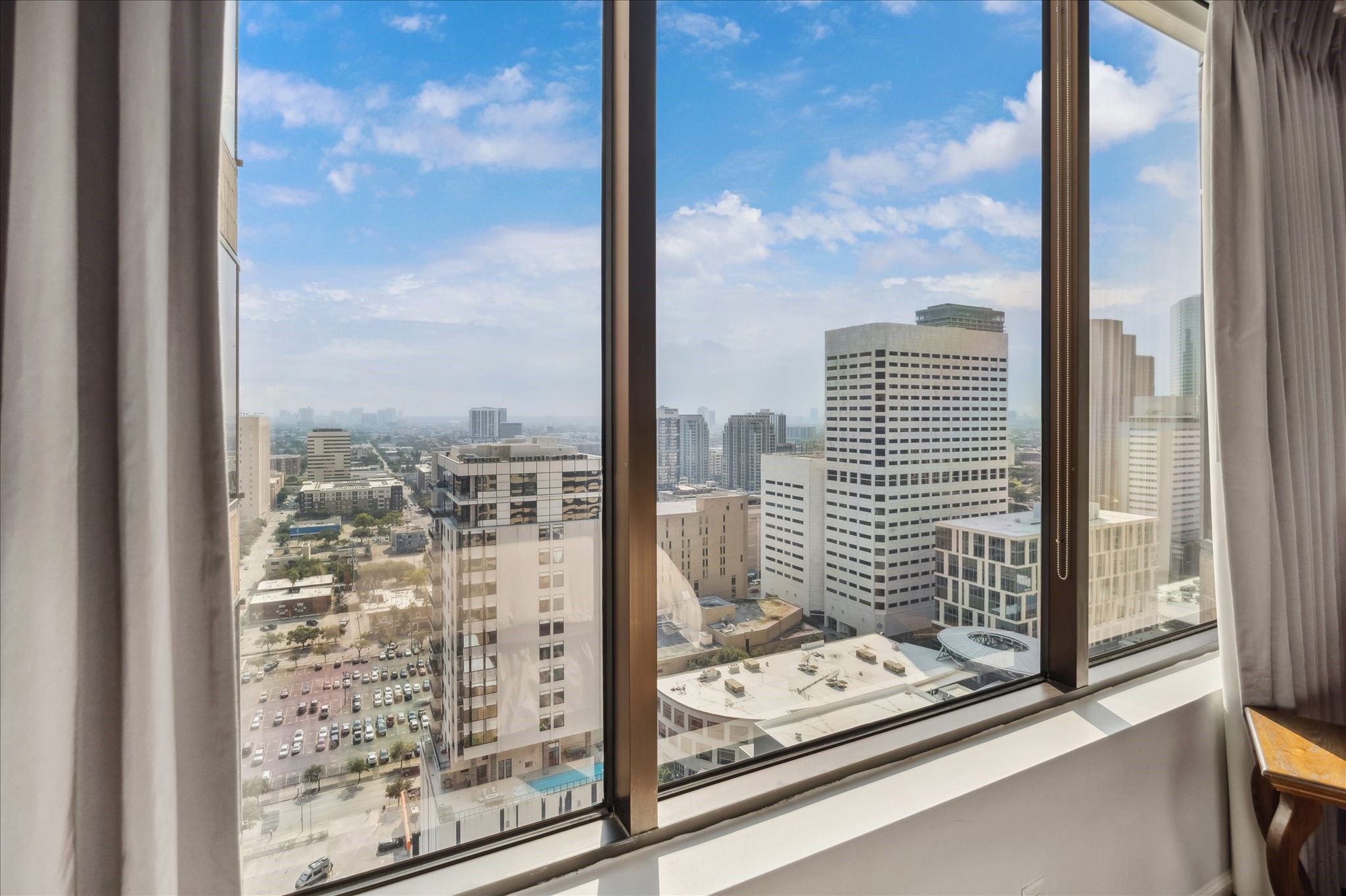 1111 Caroline Street, Unit 2908 Houston, TX 77010 - Photo 12 of 50 Wake up to sweeping city views framed by large windows. From this vantage point, the energy of downtown Houston unfolds just beyond your window, blending urban vibrancy with the comfort of a private retreat.